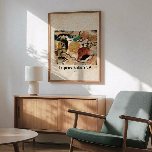 May include: Abstract expressionist artwork poster in wooden frame hanging above mid-century modern wooden credenza with white table lamp. Green upholstered armchair with wooden arms sits nearby. The colorful abstract painting features swirling forms in yellow, orange, red, green and black on cream background. Natural sunlight streams across white wall creating geometric shadows in minimalist living room setting.