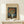 May include: Framed Van Gogh poster print featuring orange poppies in a white vase against blue background, displayed on light wood surface with small wrapped gift box decorated with greenery sprig beside it