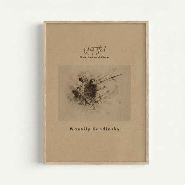 Abstract sketch artwork by Wassily Kandinsky featuring dynamic black ink lines and gestural marks on beige paper, displayed in a light wood frame against a white wall. The composition shows flowing, energetic strokes with darker concentrated areas creating movement and spontaneous expression in monochromatic tones.