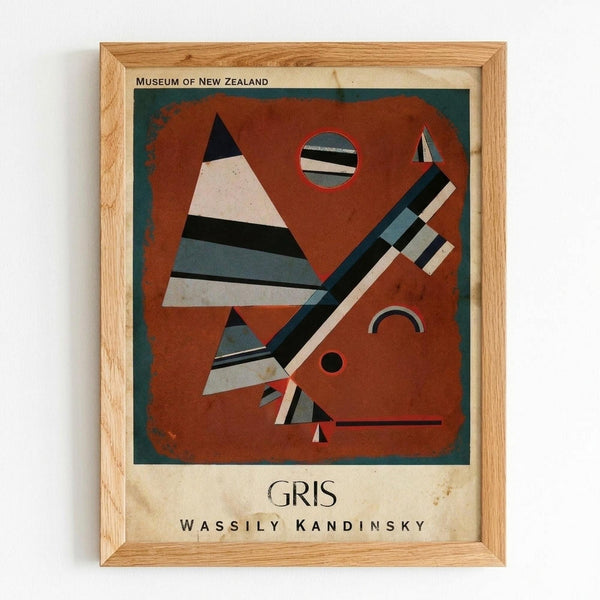 Framed abstract art poster featuring geometric shapes in rust orange, teal, black and white. Angular triangles, circles, and diagonal striped elements create a modernist composition against a dark green border. The vintage-style print shows "GRIS" and "WASSILY KANDINSKY" text below the artwork, with "MUSEUM OF NEW ZEALAND" at the top. Displayed in a light wood frame against a white wall.