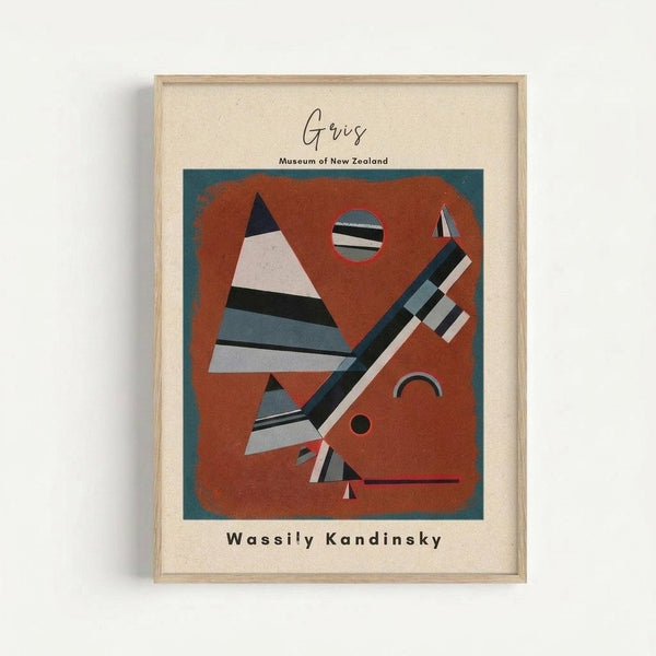 Framed abstract art print featuring geometric shapes in rust orange, teal, black, white and gray. The composition includes striped triangles, circles, and angular forms arranged on a burnt orange background with teal border. Displayed in light wood frame with cream matting against white wall. Text reads "Goris Museum of New Zealand" and "Wassily Kandinsky" in modern typography.