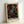 May include: Framed poster print with colorful dot pattern artwork on black background, featuring swirling circles and organic shapes in vibrant blues, oranges, pinks, yellows and greens. Text reads "YAYOI KUSAMA" and "TOKYO" with Japanese characters below. Light wooden frame sits against white wall, showing polka dot psychedelic design reminiscent of contemporary Japanese art style.