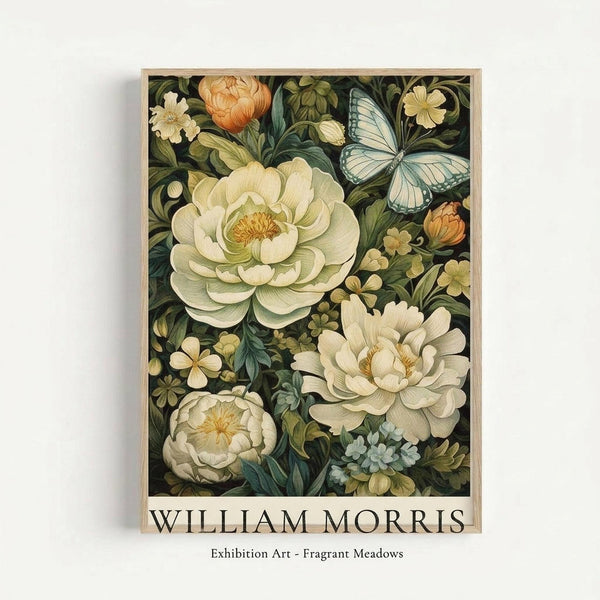 Framed botanical art print featuring cream and white peonies with orange buds, pale blue butterfly, and small flowers on dark green background. The illustration shows detailed vintage-style florals with layered petals and flowing leaves. Text at bottom reads "WILLIAM MORRIS" and "Exhibition Art - Fragrant Meadows" in serif font. Light wood frame against white wall.