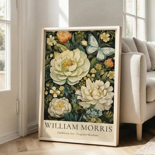 May include: Framed botanical art poster featuring cream and coral peonies, blue butterfly, and small wildflowers on dark green background, displayed in light wood frame leaning against white wall next to beige upholstered chair in bright room with large windows.
