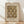 May include: Framed vintage William Morris textile pattern poster in warm brown and cream tones, featuring ornate paisley and floral motifs in repeating design. Print shows museum attribution text and artist dates. Natural wood frame leans against white wall on light wooden floor with soft natural lighting creating diagonal shadows.