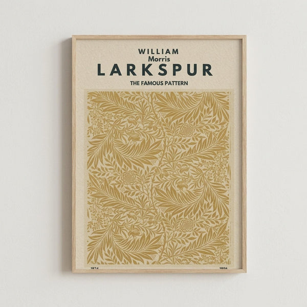 May include: Framed botanical art print in light wood frame hanging on white wall. Features intricate golden-brown floral pattern with flowing leaves, stems and small round flowers on cream background. Victorian-style decorative wallpaper design with organic, swirling motifs creating dense, repeating pattern throughout rectangular vertical format.