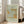 May include: Framed art print with sage green background featuring ornate botanical pattern in golden yellow and mint green tones, displaying "St James The MET Museum 1881 William Morris" text. Light wood frame leaning against white wall beside beige upholstered chair in bright, naturally-lit room with hardwood floors.