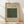 May include: Framed poster with beige background displaying green ornate floral pattern sample, black text reading "ISPAHAN FAMOUS PATTERN (1834-1896)" and "William Morris" signature, natural wood frame leaning against white wall on light wooden floor with soft window shadows