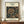 May include: Framed vintage botanical poster displaying intricate honeysuckle pattern in deep navy blue and golden tones, mounted on cream background with museum-style typography. Print sits on warm wood sideboard beside white ceramic vase and stacked books against pale wall with classic molding.