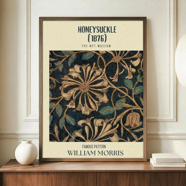 May include: Framed vintage botanical poster displaying intricate honeysuckle pattern in deep navy blue and golden tones, mounted on cream background with museum-style typography. Print sits on warm wood sideboard beside white ceramic vase and stacked books against pale wall with classic molding.