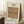May include: Framed art print featuring an intricate botanical pattern with peacocks and dragons in muted coral, sage green, and blue tones against a cream background. The vintage-style poster leans against a white wall corner on a textured white rug, with a coffee cup on a wooden block nearby and soft natural lighting creating shadows.