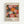 Framed exhibition poster featuring vibrant circular and radial patterns in pink, orange, yellow, and white against a dark polka-dotted background. The artwork displays organic, flower-like forms with radiating lines and dots. Text shows dates "28. APRIL - 14. MAI 1984" at top, "YAYOI KUSAMA" in large black letters, Japanese characters, and "MUSÉE D'ART MODERNE DE LA VILLE DE PARIS" at bottom. Light wooden frame against white wall background.