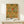 May include: Framed botanical poster with ornate floral pattern featuring large blooming flowers in golden yellow and coral red tones with green foliage on cream background, displayed on light wood console table next to small white gift box with dried sprig, against neutral wall in modern interior setting.
