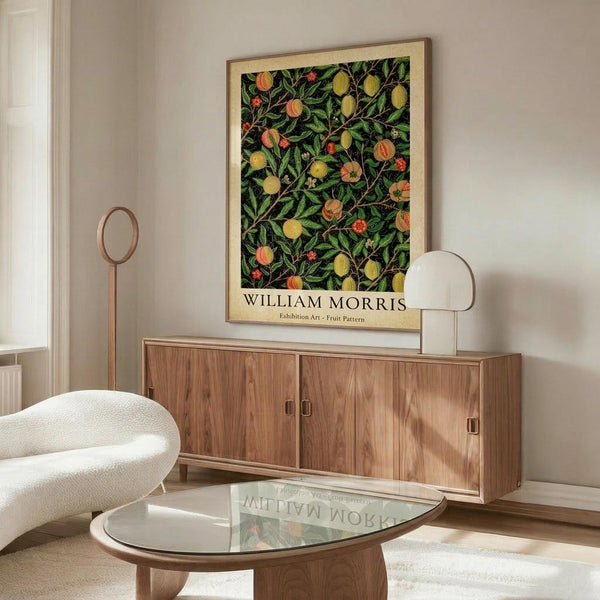 May include: Framed botanical art print featuring William Morris fruit pattern with green leaves, yellow lemons, peaches and small red flowers on dark background, displayed above walnut credenza in modern living room with white curved chair, glass coffee table, and floor lamp