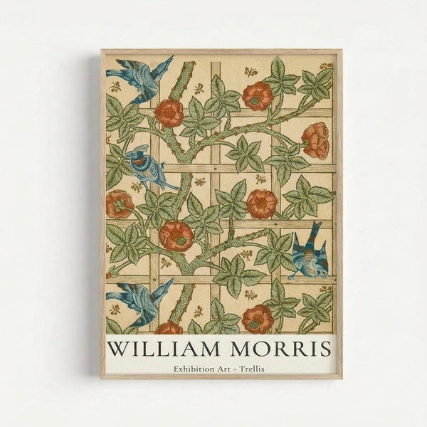 Framed art print featuring William Morris's Trellis pattern with blue birds perched among climbing rose vines with orange-red blooms and green foliage on a cream background. The botanical design shows intricate details with a wooden lattice structure. Text at bottom reads "WILLIAM MORRIS Exhibition Art - Trellis" in black letters. Natural wood frame against white wall.