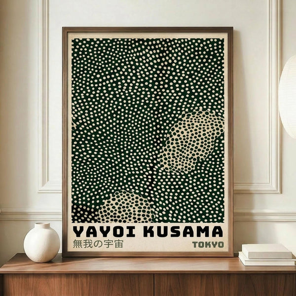 May include: Framed poster with black and cream polka dot pattern creating an abstract design, displayed on wooden sideboard next to white ceramic vase and books. Wood frame against white paneled wall in modern interior setting.
