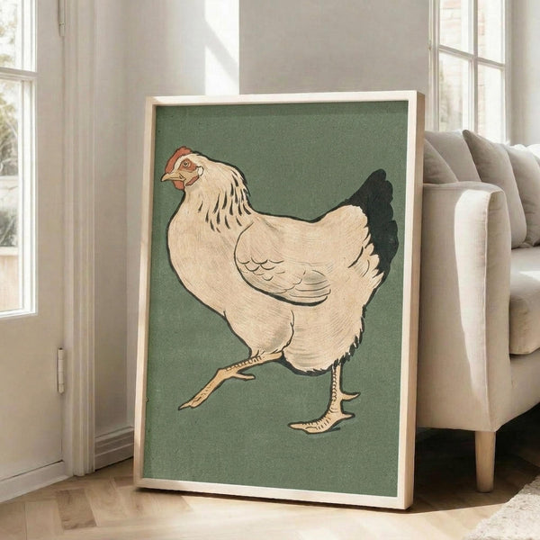 May include: Large framed vintage Japanese woodblock print of a walking hen displayed in a bright living room. The artwork features a cream-colored chicken with black tail feathers and red comb against sage green background, housed in natural wood frame. Print leans against white wall next to beige upholstered chair with windows showing natural light.
