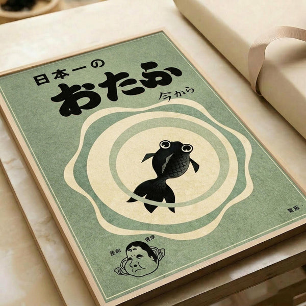 May include: Vintage-style Japanese poster with sage green background featuring black silhouette of a goldfish in the center surrounded by cream-colored concentric ripple circles. Bold Japanese characters at top, smaller character in corner, and illustration of traditional Japanese face at bottom. Print displayed on white paper with beige ribbon visible in corner, resting on light wooden surface.