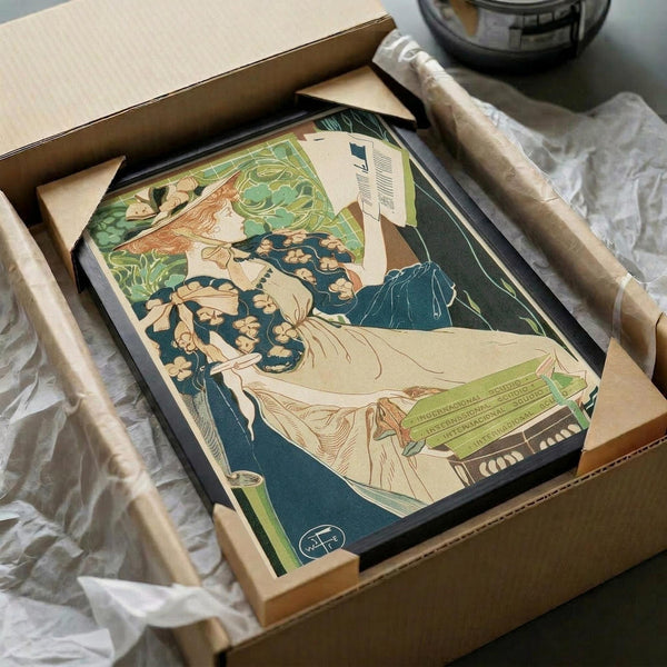 Art Nouveau poster featuring a woman with flowing red hair in white dress reclining among green foliage and blue floral patterns. Vintage advertisement print in black frame, packaged in brown cardboard box with protective white tissue paper on white surface.