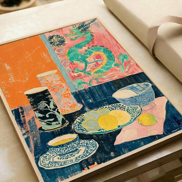 Colorful woodblock-style print featuring a still life scene with blue and white patterned teacups and bowls containing yellow citrus fruits on a pink tablecloth. Above hangs a vibrant coral and pink tapestry or screen decorated with an ornate green dragon design and medallion motif. The composition includes bold orange geometric shapes and rich navy blue areas, creating a striking contrast of warm and cool tones in an Asian-inspired artistic style.