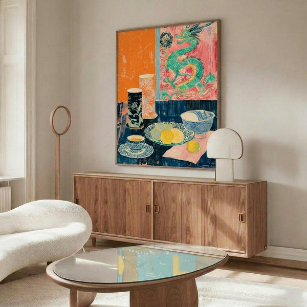 May include: Colorful still life artwork displayed above mid-century modern walnut credenza in bright living room. Painting features green dragon, ceramic bowls, and tableware in orange, pink, and blue sections. White sculptural chair and glass coffee table visible. Natural lighting creates warm shadows across wooden furniture and cream walls.