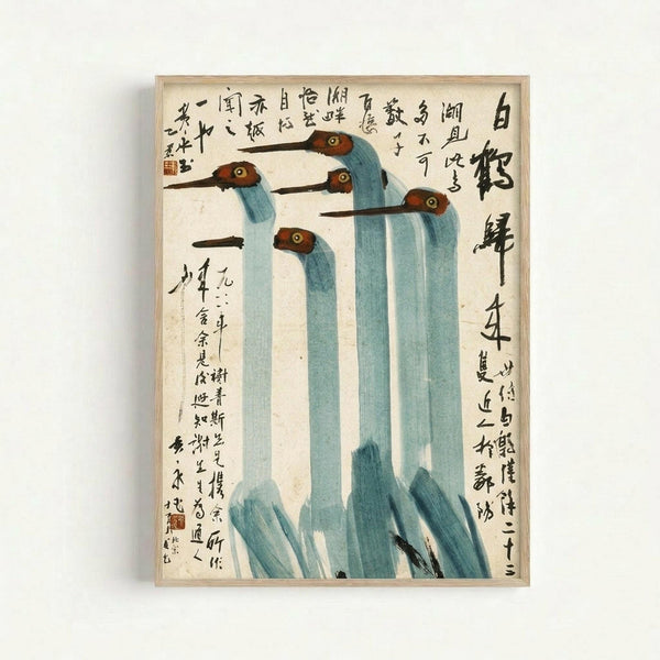 Traditional Chinese ink painting showing five elegant cranes with elongated blue-gray necks, reddish-brown heads, and long dark beaks arranged in a group composition. Black Chinese calligraphy text covers the upper and lower portions of the cream-colored paper. The artwork is displayed in a light wooden frame against a white wall, showing the delicate brushwork and muted color palette typical of mid-20th century Chinese bird paintings.