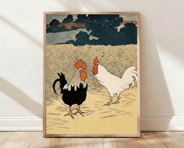 May include: Framed vintage-style print featuring two roosters - one black with orange comb and one white - standing on sandy ground beneath dramatic dark storm clouds. The artwork uses a textured, crosshatched illustration style with muted earth tones. The wooden frame leans against a white wall on light wood flooring, with soft natural lighting creating shadows.