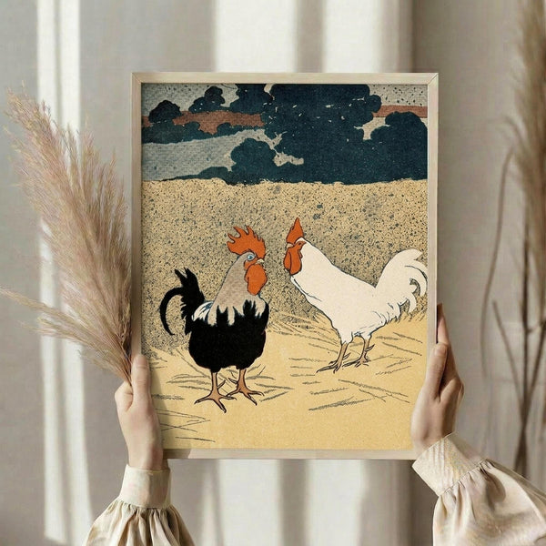 May include: Person holding framed vintage-style illustration featuring two roosters - one black with red comb and one white - standing on golden ground beneath stormy blue-gray clouds. The artwork has a textured, printmaking aesthetic with muted earth tones. Person wears cream ruffled sleeves and holds dried wheat stems, standing against white curtained window in softly lit room.