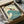 May include: Vintage-style poster showing a swimmer diving over stylized teal waves with "THE SEASIDE CALLS" and "GO BY TRAIN" text, displayed in black frame inside cardboard shipping box with protective tissue paper wrapping.