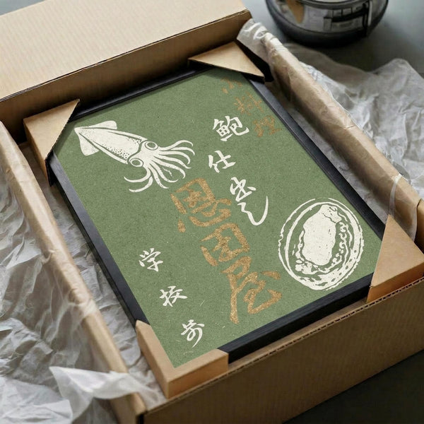 May include: Green vintage-style poster with Japanese text and white illustrated squid and abalone shell, displayed in black frame inside cardboard shipping box with protective wrapping. Wooden dowels visible alongside for hanging. Muted sage green background with cream-colored sea creatures and golden Japanese characters in traditional calligraphy style.