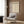 a modern living room with a white armchair, a floor lamp, and a framed poster of the Bauhaus design style.