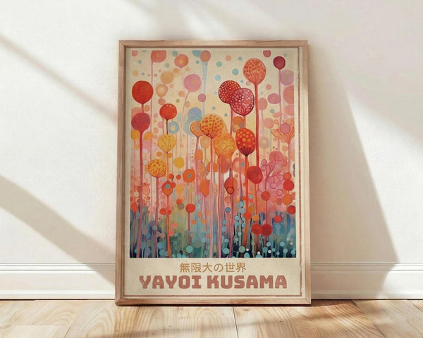 May include: Framed poster print leaning against white wall on wooden floor. Artwork features abstract forest of colorful circular tree-like forms in warm reds, oranges, and yellows transitioning to cool blues at bottom. Polka dot patterns fill many of the round shapes on thin stems. Text in Japanese characters and "YAYOI KUSAMA" appears at bottom in red letters on cream background. Natural wood frame, soft lighting creates diagonal shadows on white textured wall.
