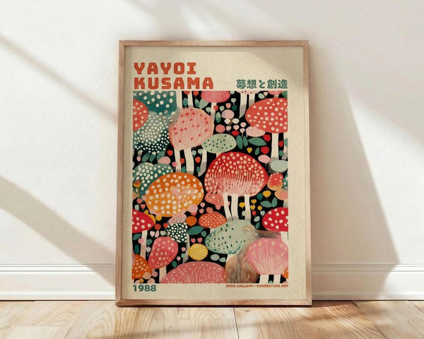 May include: Framed poster featuring colorful illustrated mushrooms in various sizes and patterns against a dark background. The artwork shows polka-dotted mushrooms in red, orange, pink, green, and yellow tones. Text reads "YAYOI KUSAMA" in red letters with Japanese characters and "1988" at bottom. Natural wood frame sits on light wooden floor against white wall with soft window light shadows.