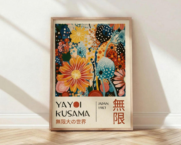 May include: Framed art print leaning against white wall on wooden floor with natural light shadows. Colorful abstract floral design with polka dots in vibrant oranges, teals, pinks, and navy blues. Text below reads "Yayoi Kusama" with Japanese characters and "Japan 1987". Light wood frame surrounds cream-colored poster with playful botanical patterns and circular motifs.
