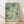 May include: Framed art print leaning against white wall on light wood floor. Abstract artwork features dreamy aqua, teal, and cream colors with floating circles, dots, and vertical drips creating an underwater or cosmic effect. Text reads "YAYOI KUSAMA" with Japanese characters and "KYOTO" below. Natural wood frame, soft window light creates shadows on textured white wall.