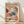 May include: Framed poster with abstract dotted pattern in coral, blue, and black colors featuring flowing organic shapes and wave-like elements at bottom. Text at top reads "YAYOI KUSAMA" with Japanese characters below. Wood frame sits on light wooden floor against white wall with natural lighting casting soft shadows.
