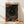 May include: Framed poster print leaning against white wall on light wood floor. Artwork features swirling cosmic design with flowing blue ribbons around black starry center, scattered orange and red circles throughout. White moon or sun in center, Japanese characters in top right corner. Red and black text at top reads "YAYOI KUSAMA MUSEUM". Natural wood frame, soft shadows from window light.