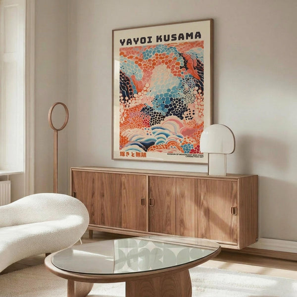 May include: Colorful abstract art poster featuring flowing organic shapes in coral, teal, and navy with dotted patterns, displayed above a mid-century modern walnut credenza in a minimalist living room. White sculptural chair and glass oval coffee table complete the scene with natural lighting casting shadows across polished floors.
