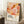 May include: Framed abstract art poster with flowing organic shapes in warm peach, coral, orange, and burgundy tones with scattered dots, displayed in light wood frame leaning against white wall. Scene shows white coffee cup on wooden block, cream textured rug, and beige blanket. Text reads "Yayoi Kusama" with Japanese characters and "Musee d'Art Moderne de la Ville de Paris" at bottom.