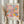 May include: Person holding framed art print featuring colorful abstract floral design with polka dots in pink, blue, yellow, and orange tones. Shows exhibition text "28. APRIL - 14. MAI 1984" and "YAYOI KUSAMA" at bottom. Light wood frame against neutral curtained background, with dried wheat stems visible on left side.