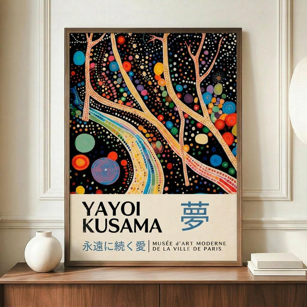 May include: A framed art poster featuring Yayoi Kusama's distinctive polka dot style with colorful circles, tree-like forms, and flowing ribbons against a black background, displayed on a wooden credenza next to a white ceramic vase and stacked books in an elegant room with white paneled walls.