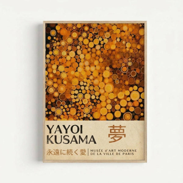 Framed art poster featuring a pattern of golden, orange, and brown circles of varying sizes densely packed together. The artwork has a warm amber color palette with circular dots creating an abstract, repetitive design. Below the image is text reading "YAYOI KUSAMA" with Japanese characters and "MUSÉE d'ART MODERNE DE LA VILLE DE PARIS" on a cream-colored background. The poster is displayed in a light wooden frame against a white wall.