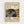 May include: Framed exhibition poster in light wood frame against white wall. Features colorful abstract artwork with flowing blue river, polka-dotted mushrooms, bare trees, and vibrant circles in orange, pink, and green. Text shows "YAYOI KUSAMA" with Japanese characters, "JAPAN 1987", and museum details including "MUSÉE D'ART MODERNE DE LA VILLE DE PARIS" with exhibition dates "28 AVRIL - 14 MAI 1984". Cream-colored background with black and red typography.