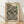 May include: Framed poster with black polka dot pattern on cream background, displayed against white textured wall on light wood floor. Features "YAYOI KUSAMA" text at top, Japanese characters in green, and "1992" date marking. The artwork shows flowing organic dots in various sizes creating an infinity net design. Natural wood frame complements the minimalist room setting with soft window light creating gentle shadows.