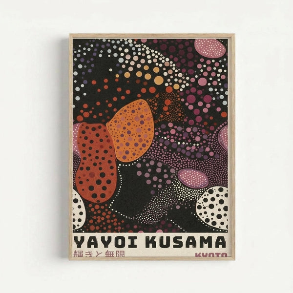 Framed poster featuring Yayoi Kusama's distinctive polka dot artwork on black background with organic shapes in orange, pink, white, and purple tones. The artist's name appears in bold black letters at bottom with Japanese characters. Artwork displays signature infinity dot patterns radiating across the composition in various sizes and densities. Light wooden frame against white wall background.