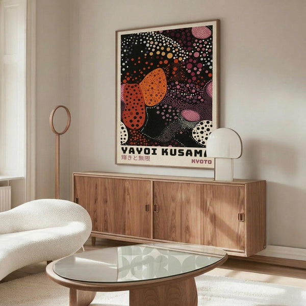 May include: Modern living room mockup showing framed colorful abstract art poster with black background and vibrant orange, pink, and white polka dot pattern, displayed above wooden sideboard with white sculptural chair and glass coffee table