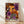 May include: Framed poster with colorful abstract dot pattern artwork leaning against white wall on light wooden floor. Features vibrant orange, purple, black and white circular designs with polka dots in Kusama's signature style. Text at bottom reads "YAYOI KUSAMA" with Japanese characters and "KYOTO". Natural wood frame, soft lighting creates gentle shadows on textured white wall.