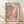 May include: Framed exhibition poster with abstract dotted artwork in coral, pink and white tones, featuring Japanese text and "YAYOI KUSAMA" at top, "TOKYO 1998" and museum details, displayed against white textured wall on light wood floor with natural lighting casting soft shadows across the scene.
