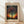 May include: Framed art print leaning against white wall on light wood floor. Features a silhouetted tree with spreading branches against a cosmic background of colorful dotted circles in blues, oranges, purples, and yellows. The tree sits on rolling hills beneath a starry sky. Text reads "YAYOI KUSAMA" at top, "TOKYO 1998" at bottom left, and Japanese characters at bottom right. Natural wood frame with cream matting.