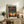 May include: Framed art print featuring a silhouetted tree with colorful polka dot foliage against a vibrant sunset sky, displayed on a rustic wooden sideboard next to a fern plant, ceramic vase, and books in a cozy living room setting with beige sofa and neutral walls.